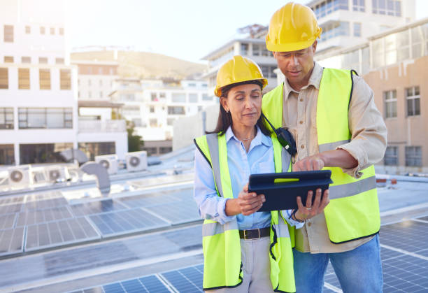 istock Engineer, man and woman with tablet for online research, schedule for building project and maintenance. Digital, people talking and construction worker with innovation, search internet and inspection 1470745332
