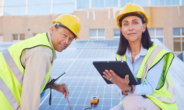 istock Tablet, solar energy or engineering team working solar panels or technology on rooftop for renewable energy. Teamwork, portrait or construction workers on a city building for maintenance inspection 1470745438