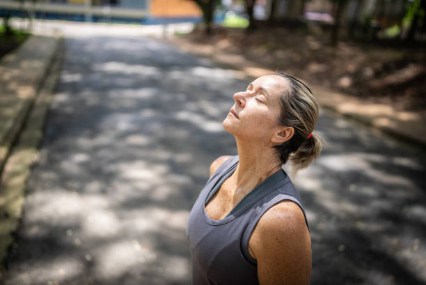 istock Mature woman doing breathing exercise in the park 1470746086