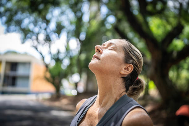 istock Mature woman doing breathing exercise in the park 1470746093