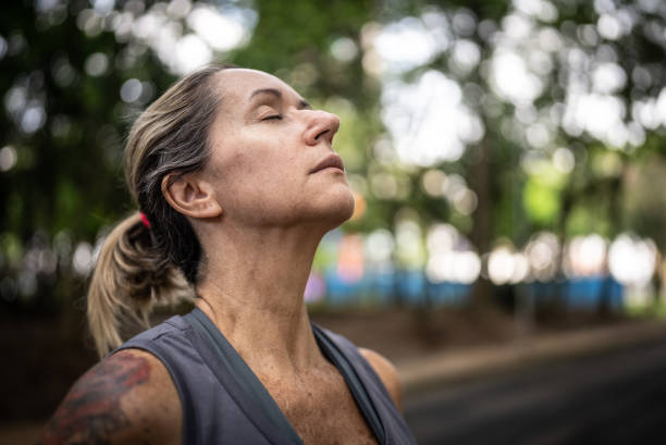 istock Mature woman doing breathing exercise in the park 1470746689