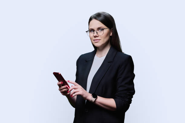 istock Young business woman using smartphone on white studio background 1470747274