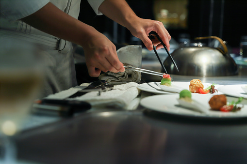 Teppanyaki chef cooking in front of guests.\nexquisite food culture.