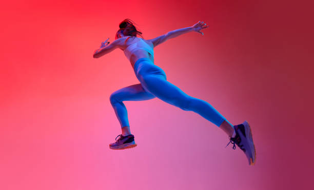 istock Bottom view. Young female professional athlete, runner in motion, training over pink studio background in neon light. Concept of sport. health and strength 1470753541