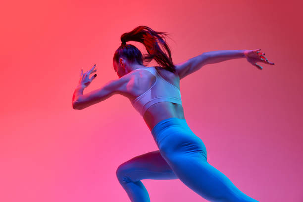 istock Strong and fast. Young female athlete, professional runner training over pink studio background in neon light. Concept of sport. health and strength 1470753547