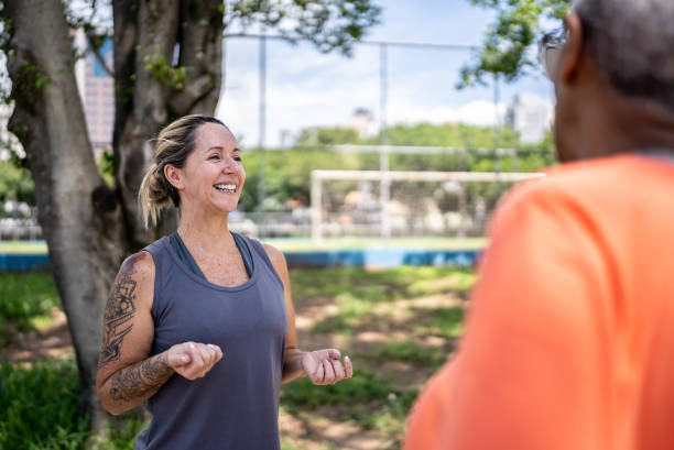 istock Fitness instructor talking to students at public park 1470753666
