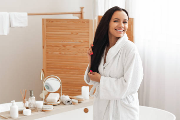 istock Cheerful Mixed Lady Posing Touching Long Brunette Hair In Bathroom 1470753899