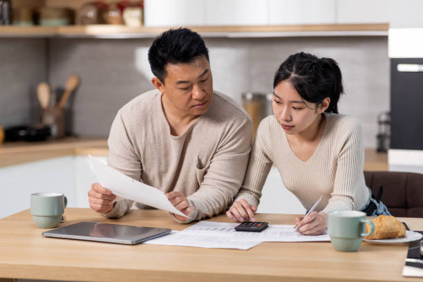 istock Serious asian family counting monthly expenses, kitchen interior 1470753971