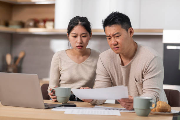 istock Shocked chinese spouses reading correspondence, kitchen interior 1470753978