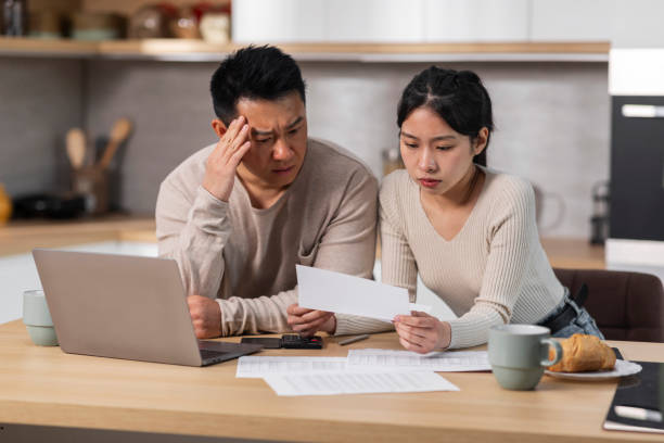istock Overwhelmed chinese spouses reading correspondence at home 1470753993