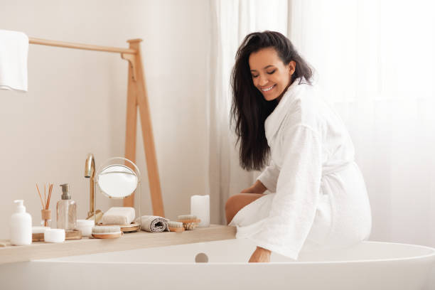 istock Happy Mixed Woman Sitting On Bathtub Preparing Bath In Bathroom 1470754797