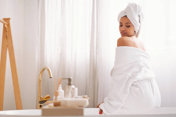 istock Female With Wrapped Towel Sitting Back To Camera In Bathroom 1470754893