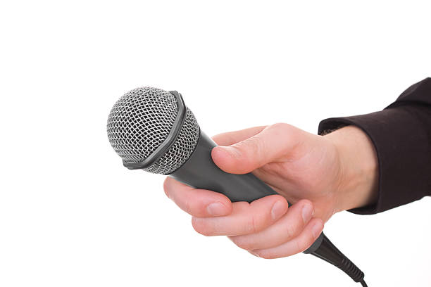 istock Male hand holding a microphone 147076281