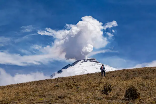 Cotopaxi in eruption, an immense column of steam rises a few thousand meters above the volcano.