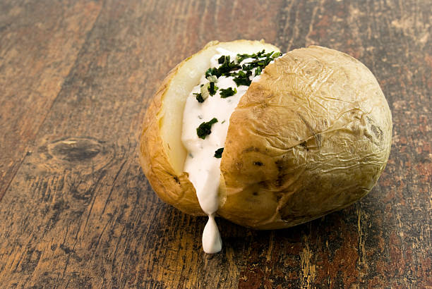 Baked potato with curd and herbs stock photo
