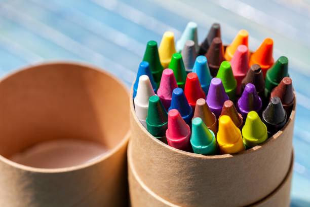 A simple pack, set of colorful wax crayons, multi colored crayon tube container object closeup, detail. Creativity, creative arts and crafts activities abstract concept, symbol, nobody, no people