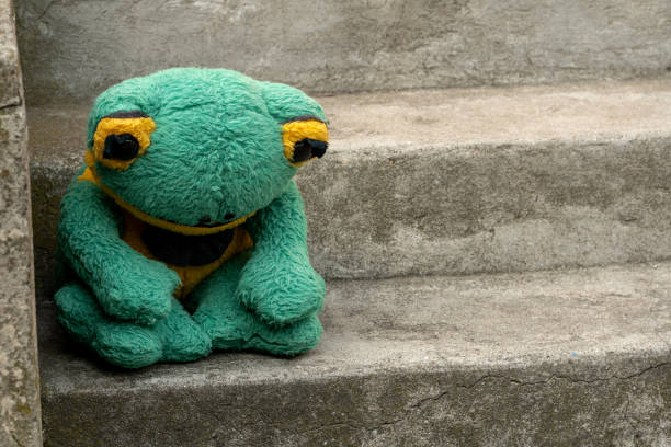 Sad depressed abandoned green frog plush toy plushie sitting on the stairs alone, feeling down, sadness, depression, alienation, loneliness being excluded social issues, mental health problems concept Sad depressed abandoned green frog plush toy plushie sitting on the stairs alone, feeling down, sadness, depression, alienation, loneliness being excluded social issues, mental health problems concept abandoned place stock pictures, royalty-free photos & images