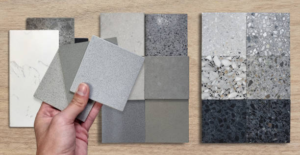 istock architect's hand holding quartz samples. materials construction on wood background. interior samples design contains multi color and pattern of terrazzo, grainy stone tiles, quartz, marble stones. 1470773818