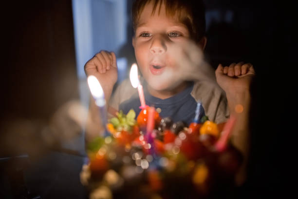 Portrait of a happy birthday girl blowing the candles on her cake and celebrating
