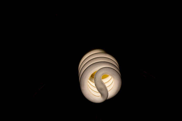 inklusive energiesparlampe in der dunklen nahaufnahme - compact fluorescent lightbulb isolated on white light bulb close up stock-fotos und bilder