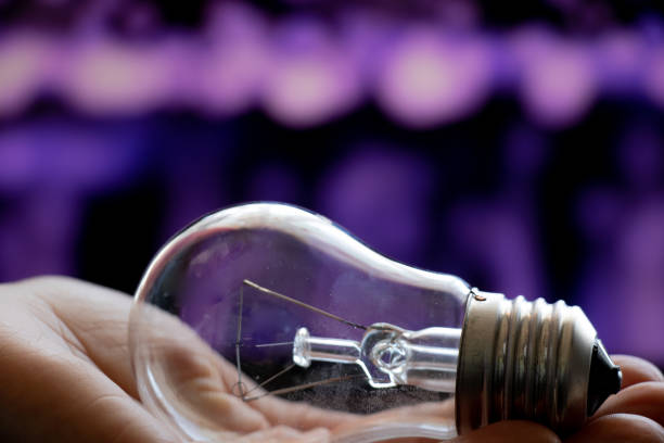 istock old incandescent light bulb in hand on blurry dark background close-up 1470776980