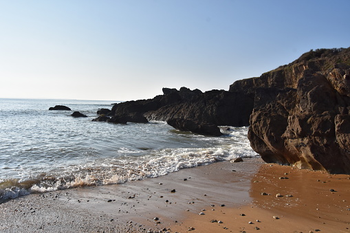 Une plage de sable ocre avec des rochers, à Clohars Carnoet en Bretagne