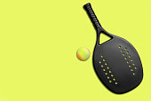 Black professional beach tennis racket and ball on yellow background. Horizontal sport theme poster, greeting cards, headers, website and app