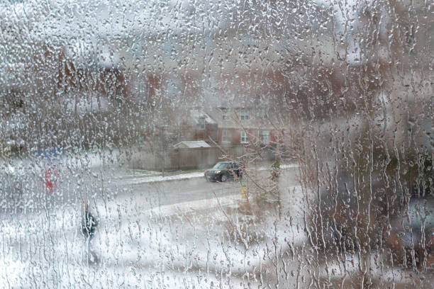 Raindrops on glass surface. Full frame view with green meadow background. Galicia, Spain.
