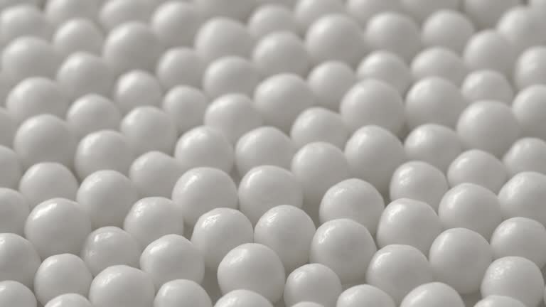 Lot of round chewy candies in white glaze. White balls dragee