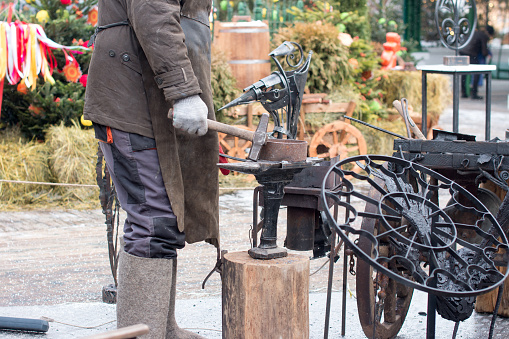 Traditional blacksmith's work. A blacksmith forges a metal product, the national holiday of Maslenitsa in Moscow on Tverskoy Boulevard