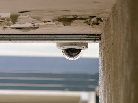 Close-up photo of a security camera placed at the top of the wall in the underpass