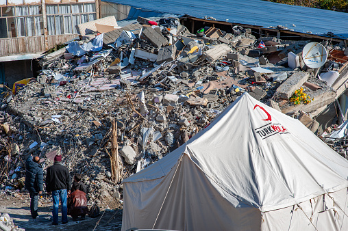 Van, Turkey - October 28, 2011: Van Earthquake 7.2 / Red Crescent tent set up near an earthquake survivor's wrecked building