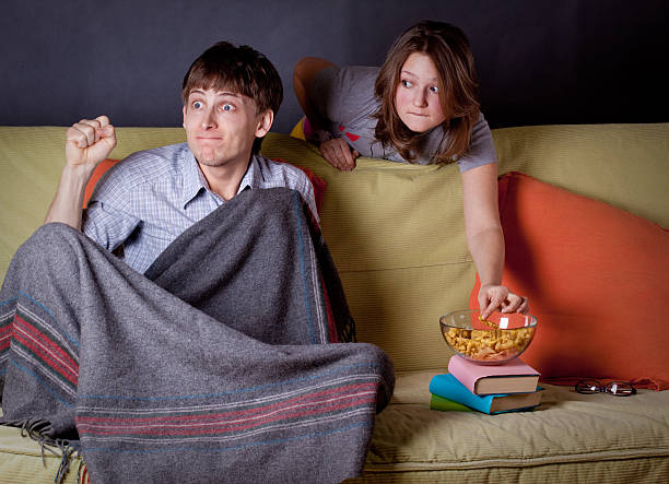 Two yong adults watching TV stock photo