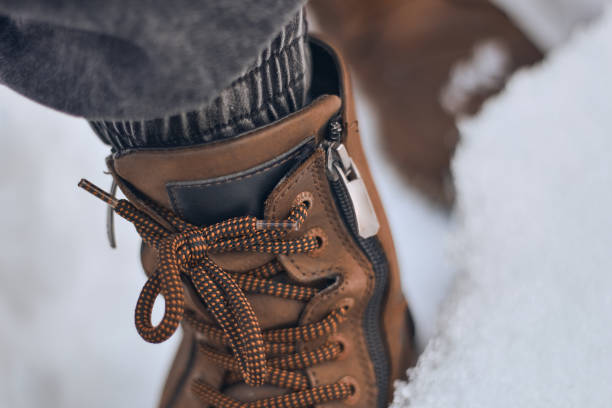 Brown boots in the snow close up.