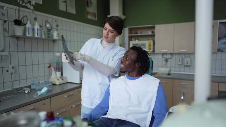 Female dentist showing X-Ray to a patient