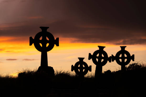 friedhof mit keltischen kreuzen, irland - celtic cross republic of ireland sunset silhouette stock-fotos und bilder