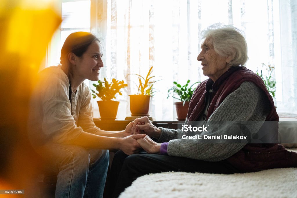 A helping hand. Volunteering and senior care. Volunteer woman caretaker talking with senior woman. Domestic Life Stock Photo