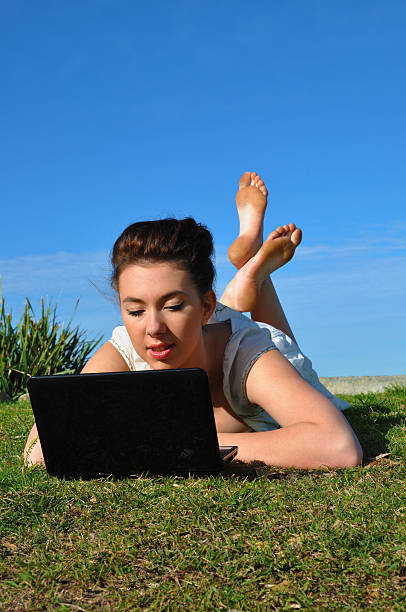 Young Girl works with her laptop in a park stock photo