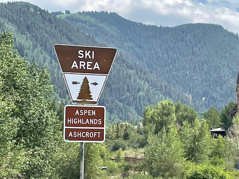 Aspen, Colorado, USA - July 16, 2021: A sign shows the way to the Aspen Highlands ski area and the Ashcroft ghost town near Aspen in the Castle Creek Valley of the Rocky Mountains.