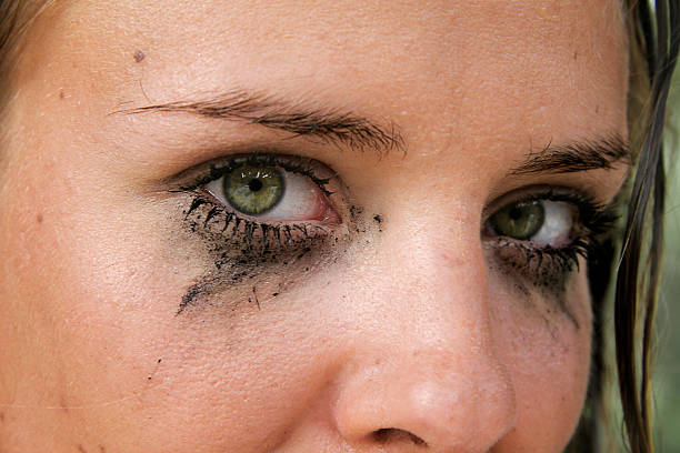 A woman's eyes with smudged makeup and mascara Close-up of green eyes with dirty make-up ugly people crying stock pictures, royalty-free photos & images