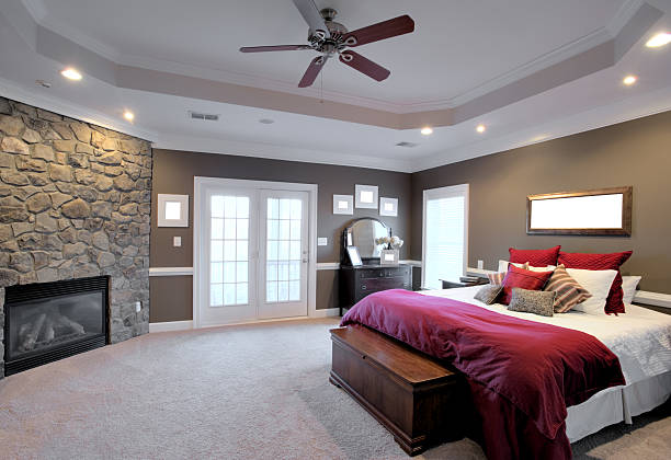 Large Bedroom Interior Interior of a large modern bedroom with a fireplace and ceiling fan. Horizontal format. french doors stock pictures, royalty-free photos & images
