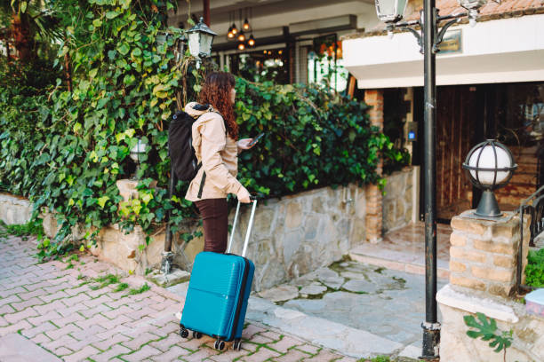 istock Young woman with suitcase searching hotel 1470792998