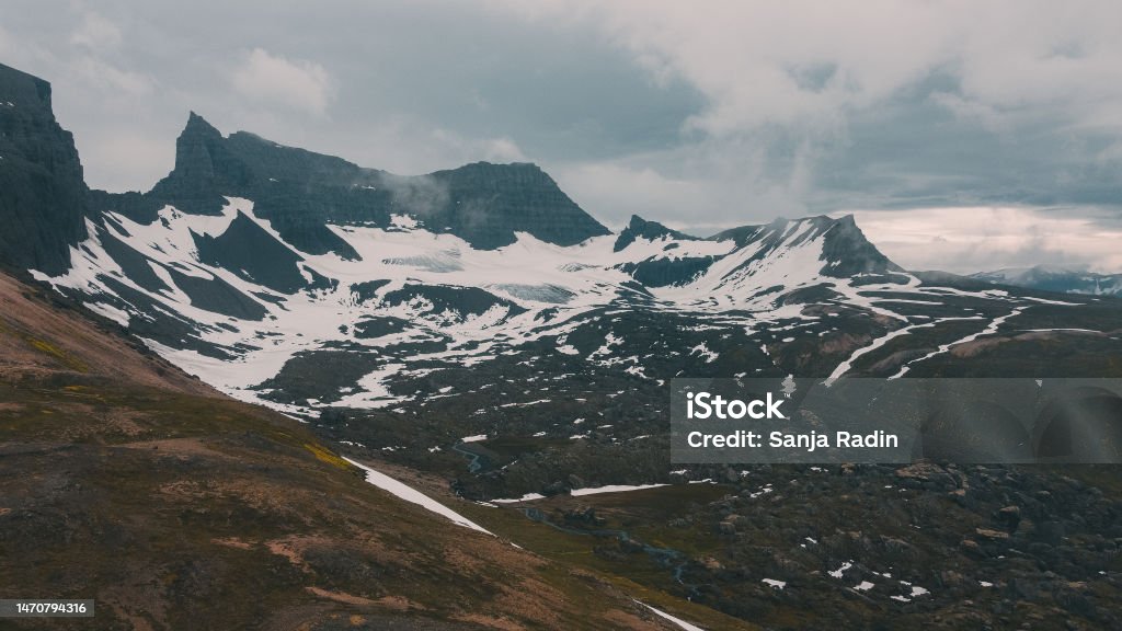 Island mountains covered in snow Islandic mountain range on a cloudy day Adventure Stock Photo