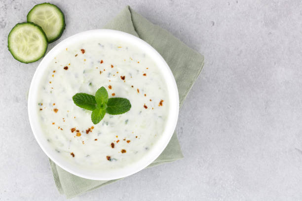 Indian raita sauce with yogurt, cucumber and mint on a gray background. Top view. Indian food. Greek tzatziki sauce. Indian raita sauce with yogurt, cucumber and mint on a gray background. Top view. Indian food. Greek tzatziki sauce. tzatziki stock pictures, royalty-free photos & images