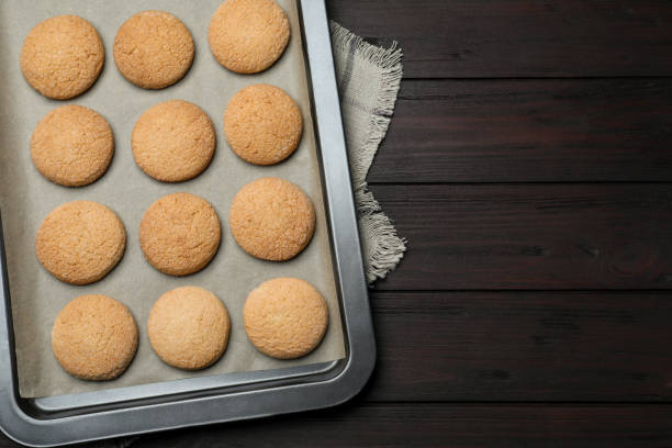 istock Baking sheet with delicious sugar cookies on wooden table, top view. Space for text 1470797364