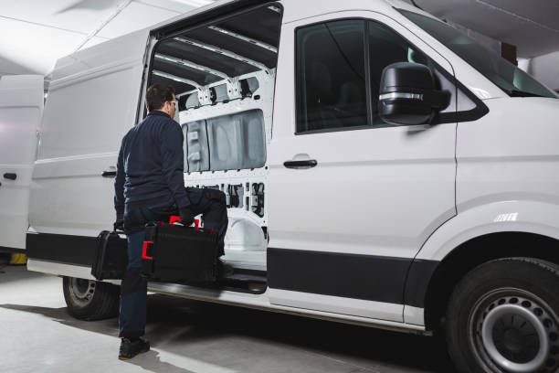 Ready for work with a determined attitude, a worker with his tools getting into his white van. stock photo