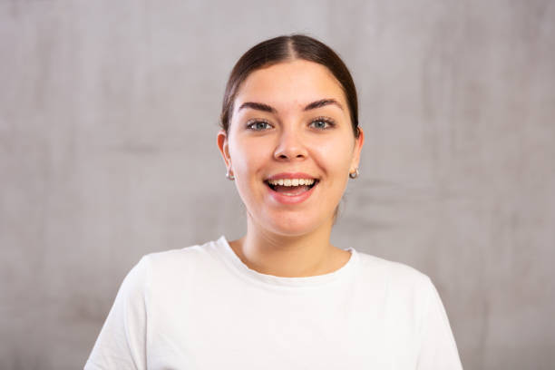 istock Cheery young woman posing happily against gray shadeless background 1470797673