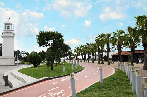 Street of resort town with lighthouse, palms and two way bicycle lane