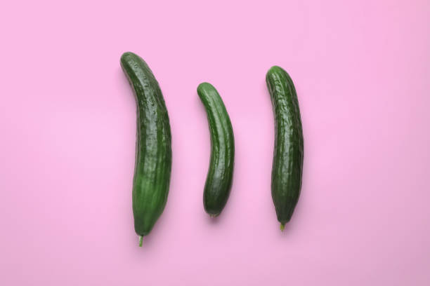 istock Fresh ripe cucumbers on pink background, flat lay 1470797862