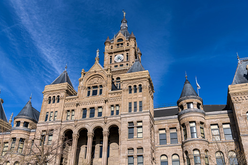 A low-angle and wide-angle view of the historic Salt Lake City and County Building, against blue sky, on a sunny Winter evening. Downtown of Salt Lake City, Utah, USA.